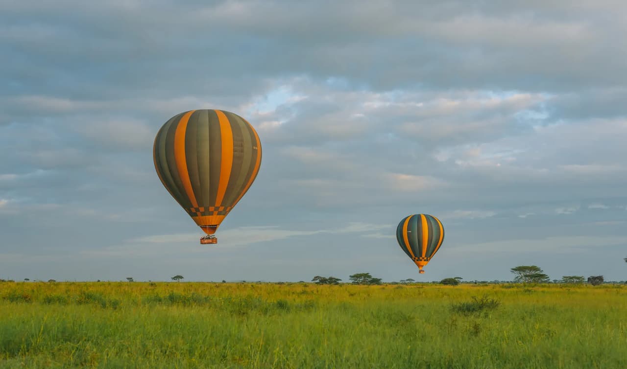 Hot-air balloons crossing green-season plains in the Serengeti