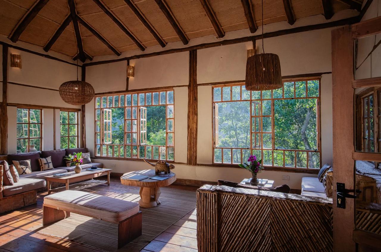 A lodge lounge opens through tall windows to the forest