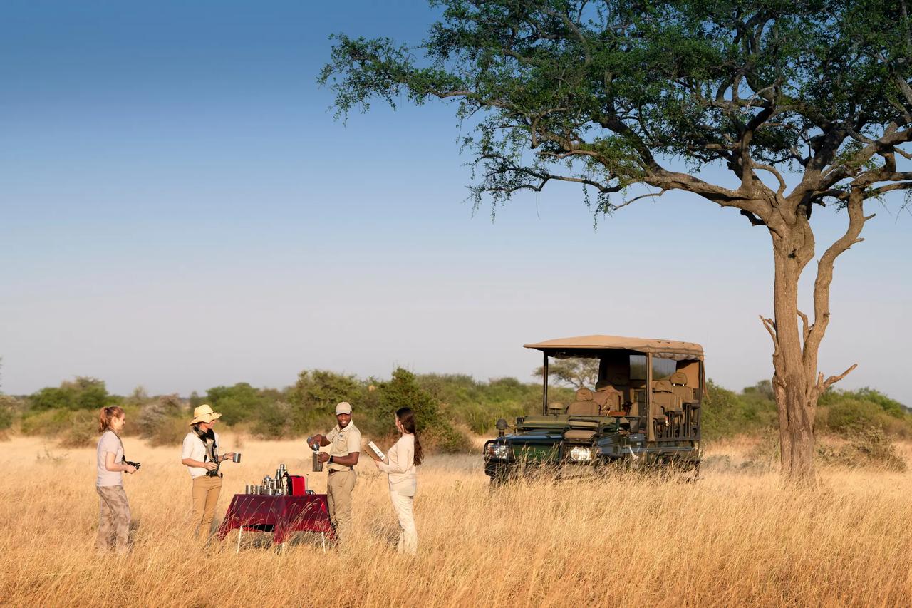 Guests pausing for morning coffee during a game drive in the Serengeti