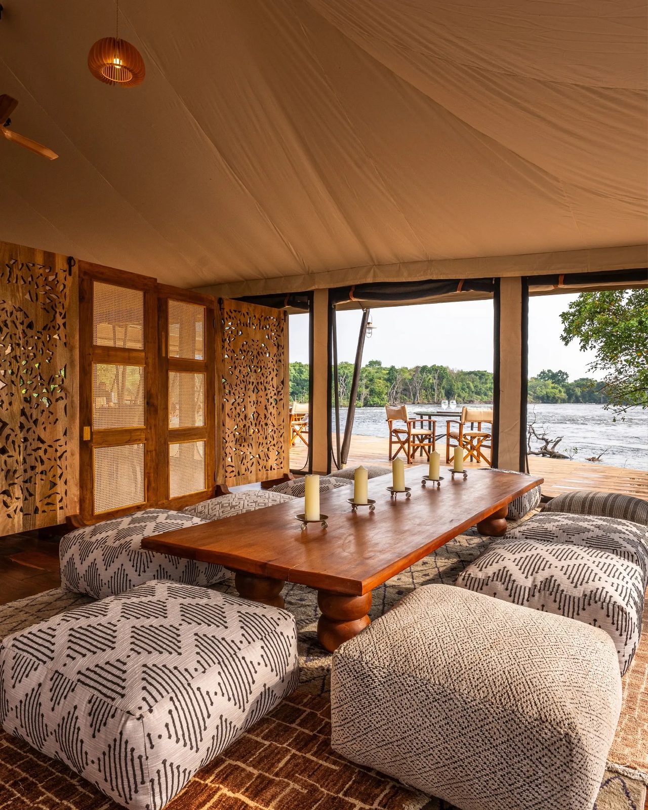 A tented lounge opens to the river beyond