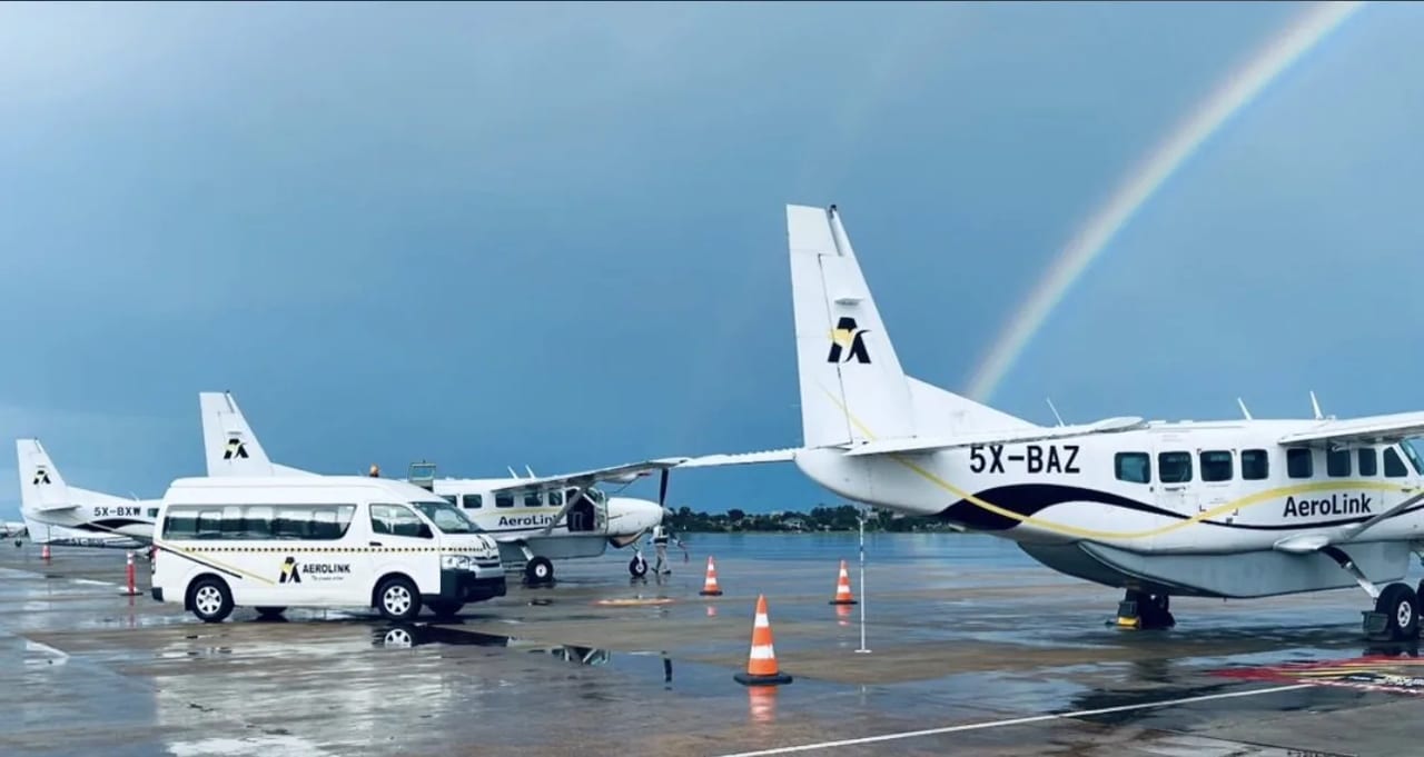Charter aircraft wait on the Entebbe apron beneath a rainbow