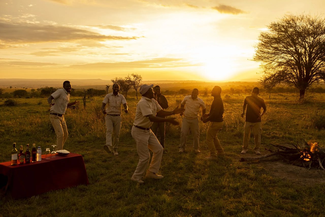 Guests gathered for sundowners on the Mara plains at dusk