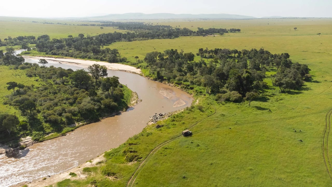The Mara river winds through green plains seen from above