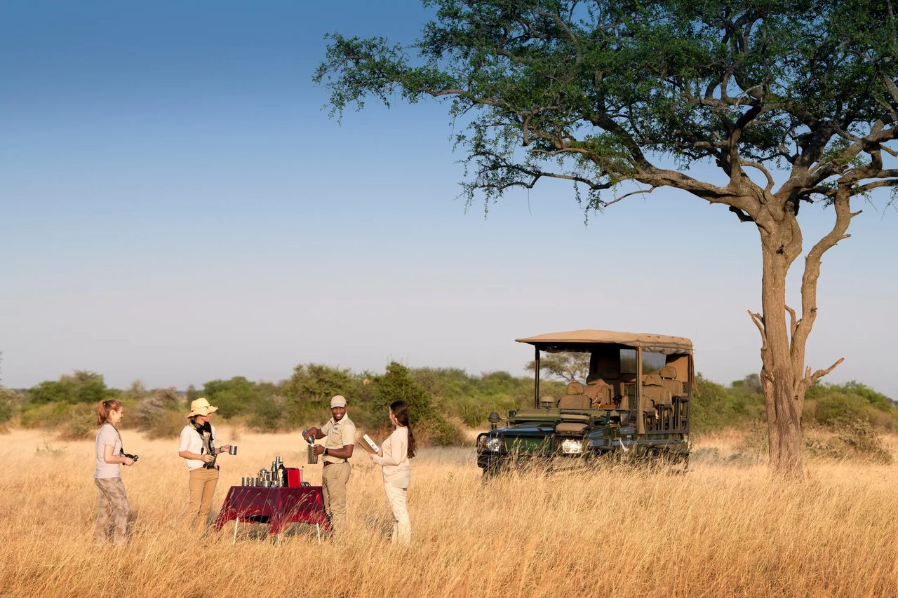 Guests pausing for morning coffee during a game drive in the Serengeti