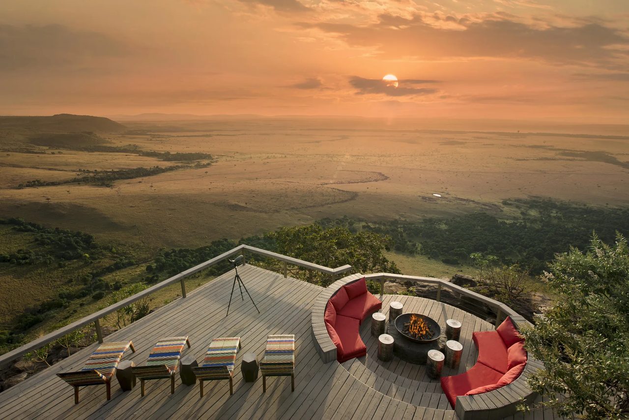 A firepit lounge looks out over the Mara escarpment at dusk