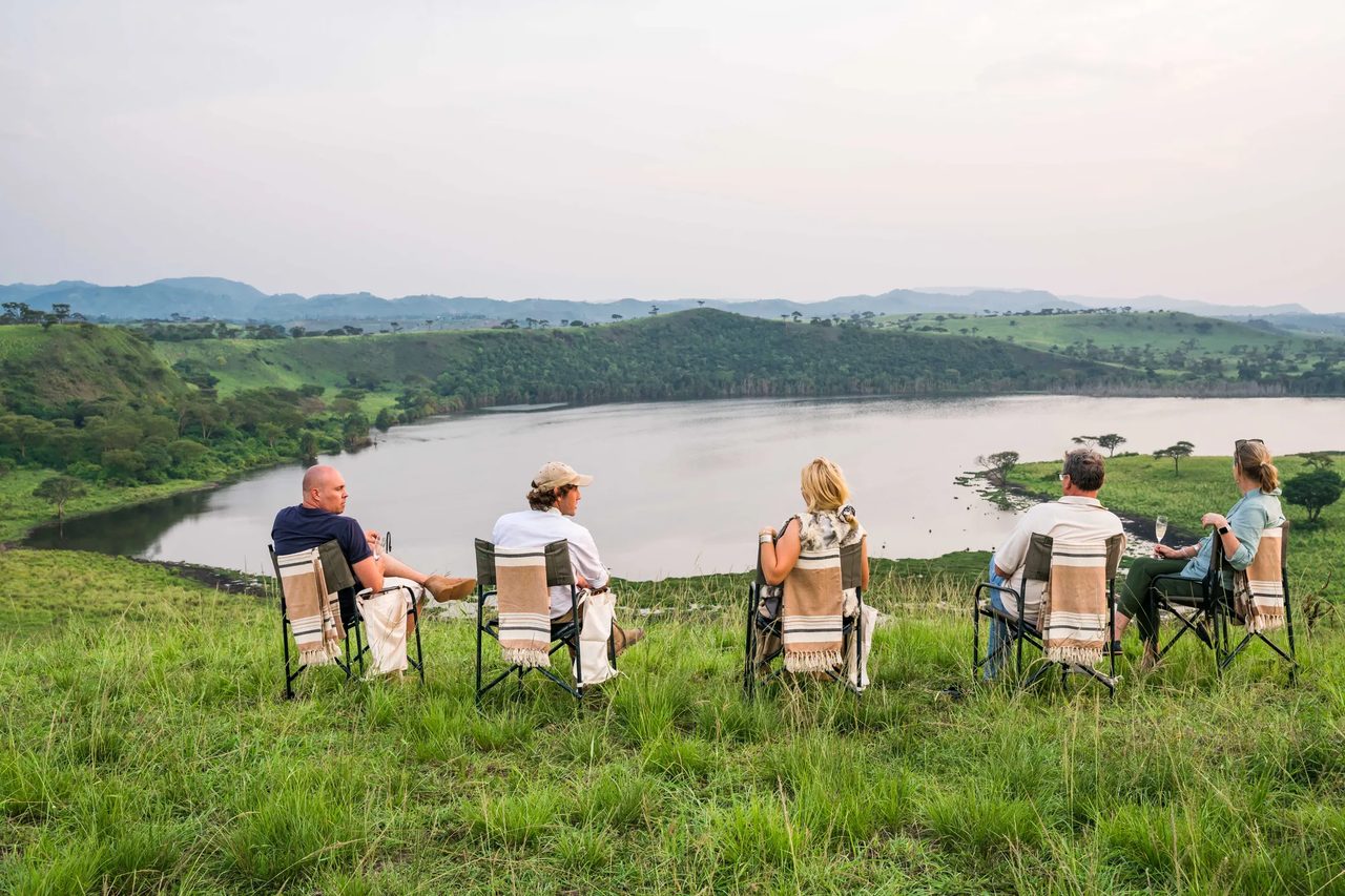 Sundowners set above crater lakes and cultivated hills in western Uganda, late light on the water.