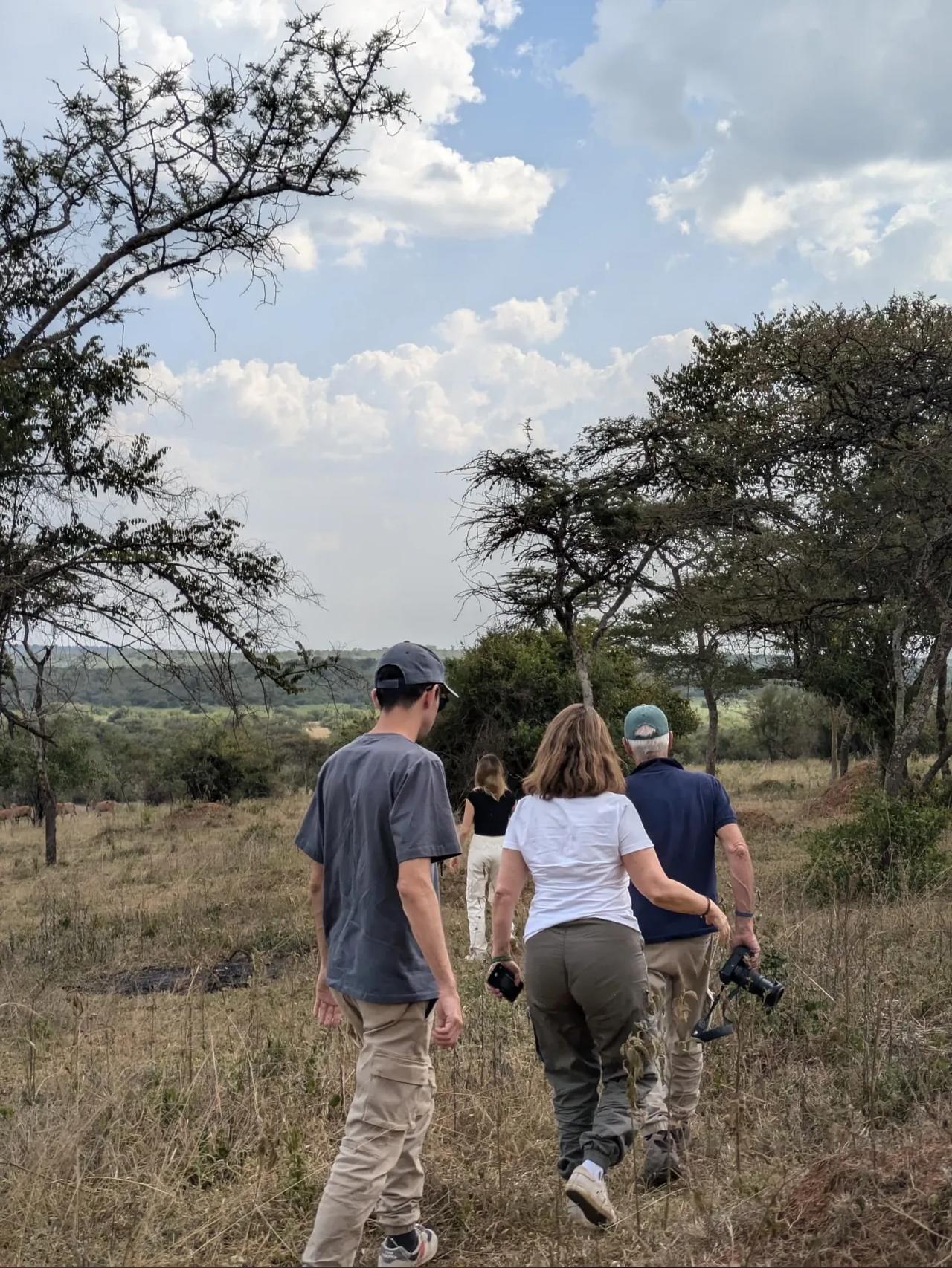 A family walks together across open safari country