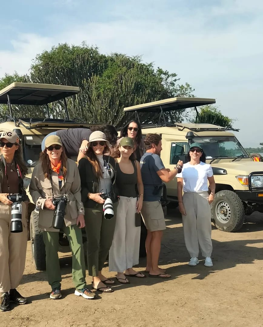 A trekking group gathers beside the vehicle at the trailhead