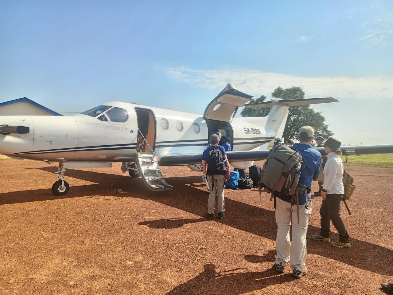 Guests boarding a light aircraft on a bush airstrip for the flight to Kidepo