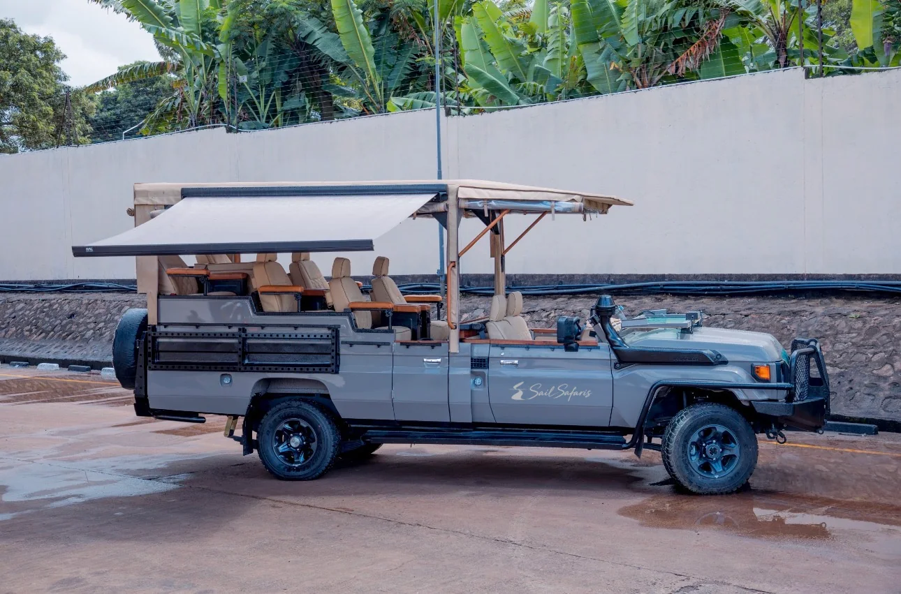 A branded, open-sided Sail Safaris DMC vehicle