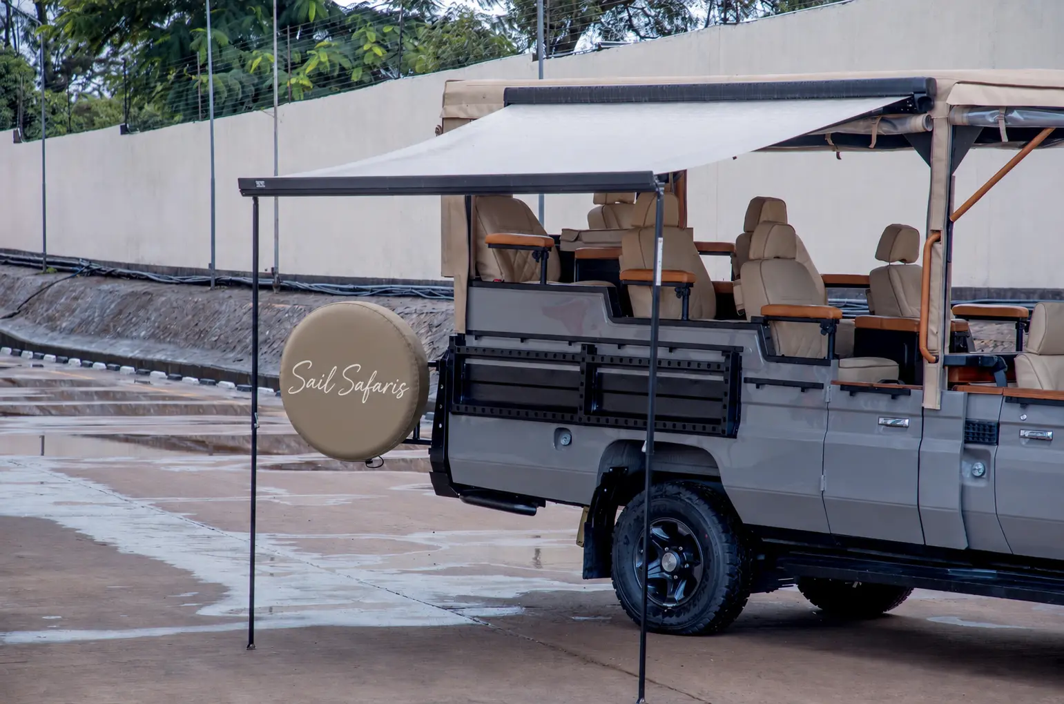 An open-sided Sail Safaris vehicle with individual seats, canopy and branded spare-wheel cover