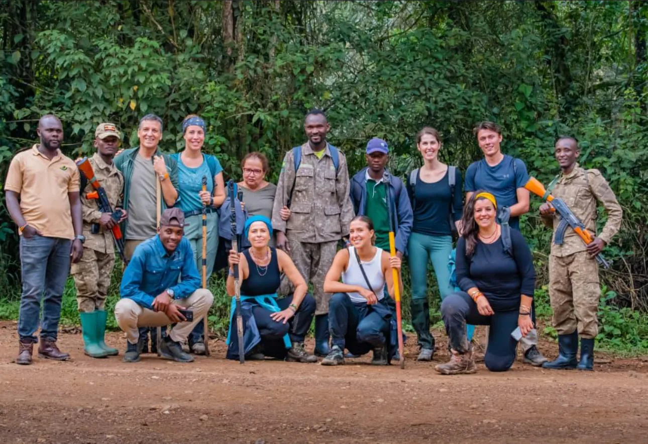 Two trekkers descend a forest path with a ranger after a gorilla morning