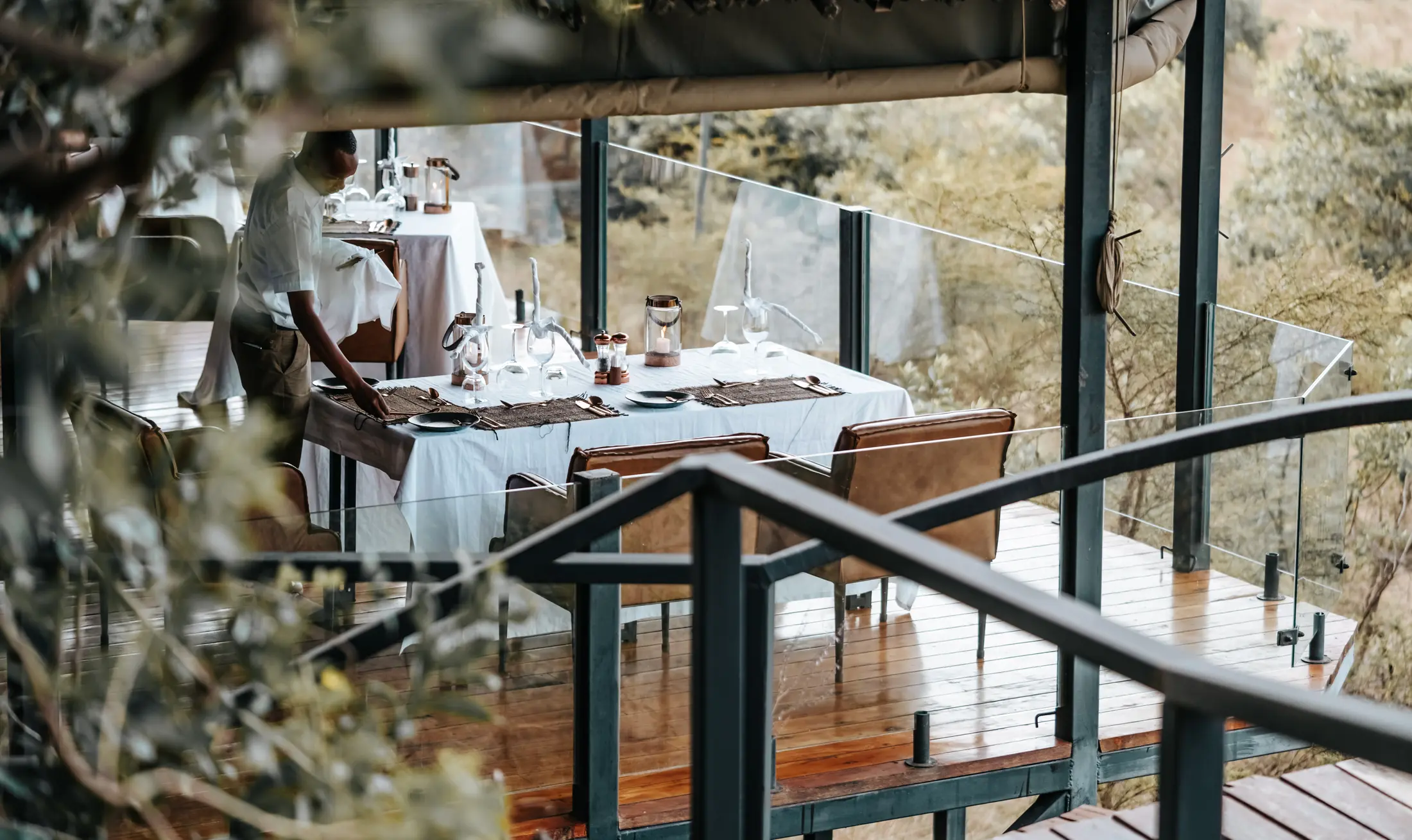 Camp team preparing a dining table before guests arrive in the Maasai Mara