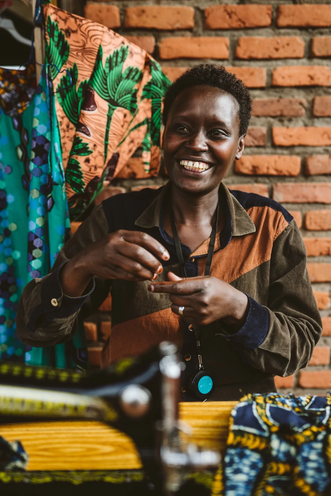A seamstress smiles at her machine in a community workshop