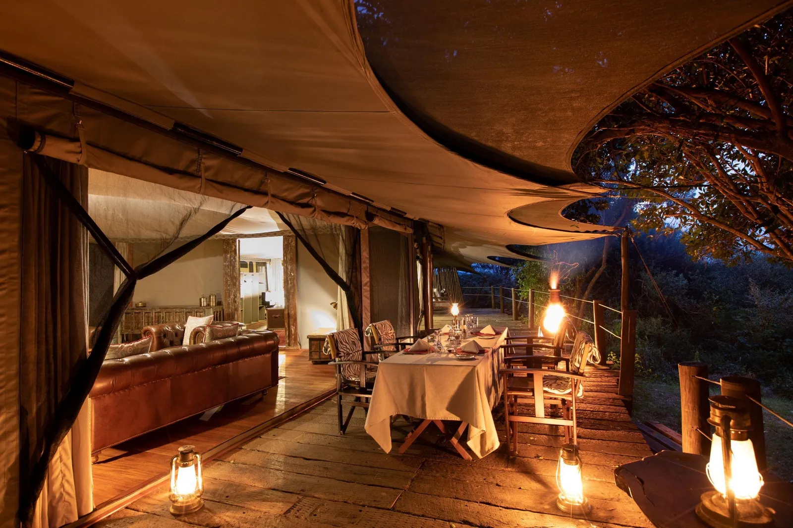 A lantern-lit camp deck glows against the night