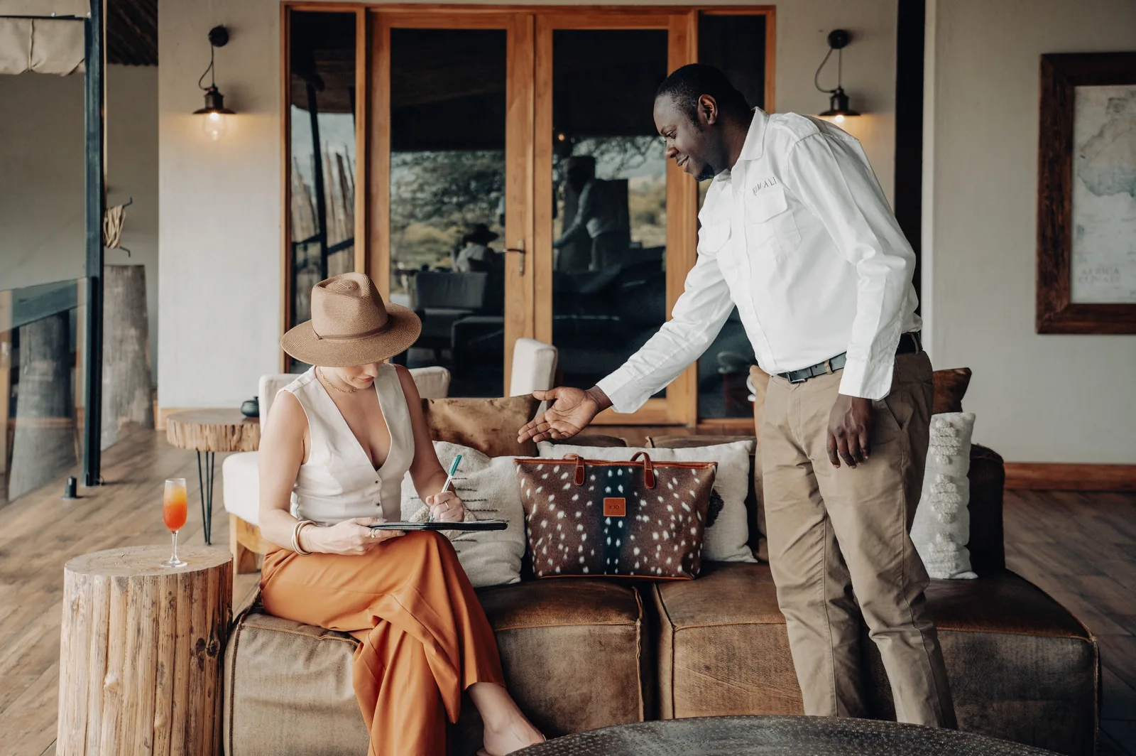 A guest signs the register at a safari lodge on arrival