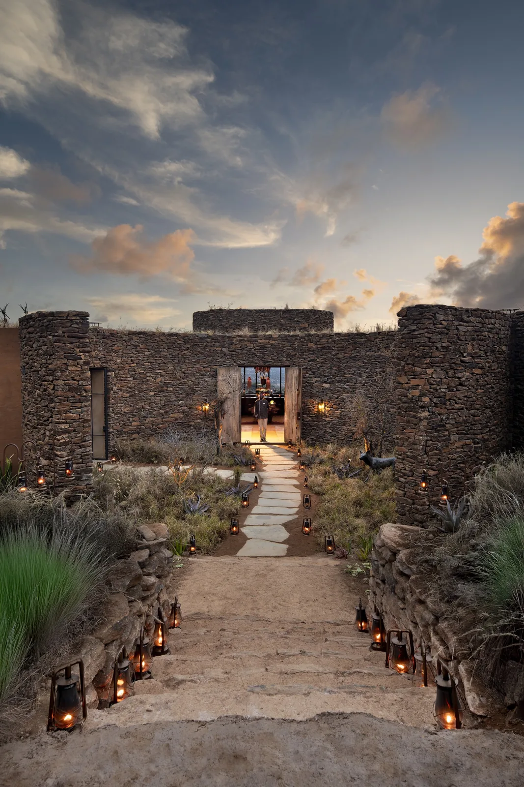Lanterns light an arrival courtyard at dusk