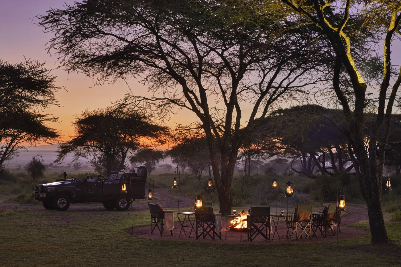 Sundowners arranged at a camp boma beside a safari vehicle
