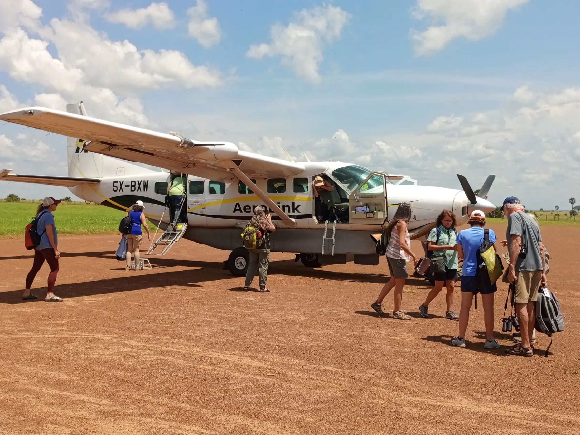Guests boarding a small Aerolink aircraft at an East African bush airstrip