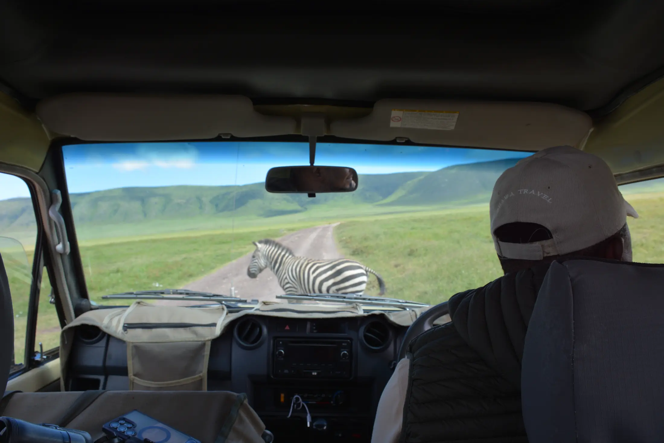 Zebra crossing ahead of a safari vehicle on an overland transfer