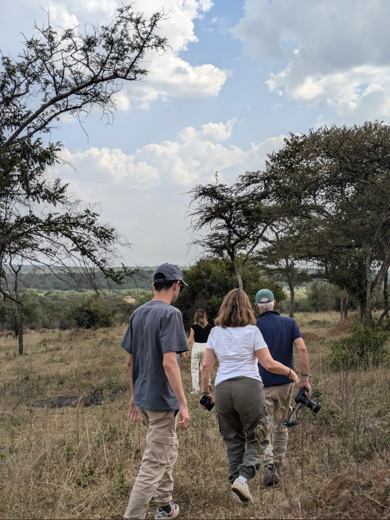 A family walks single file on a guided safari with a Sail guide