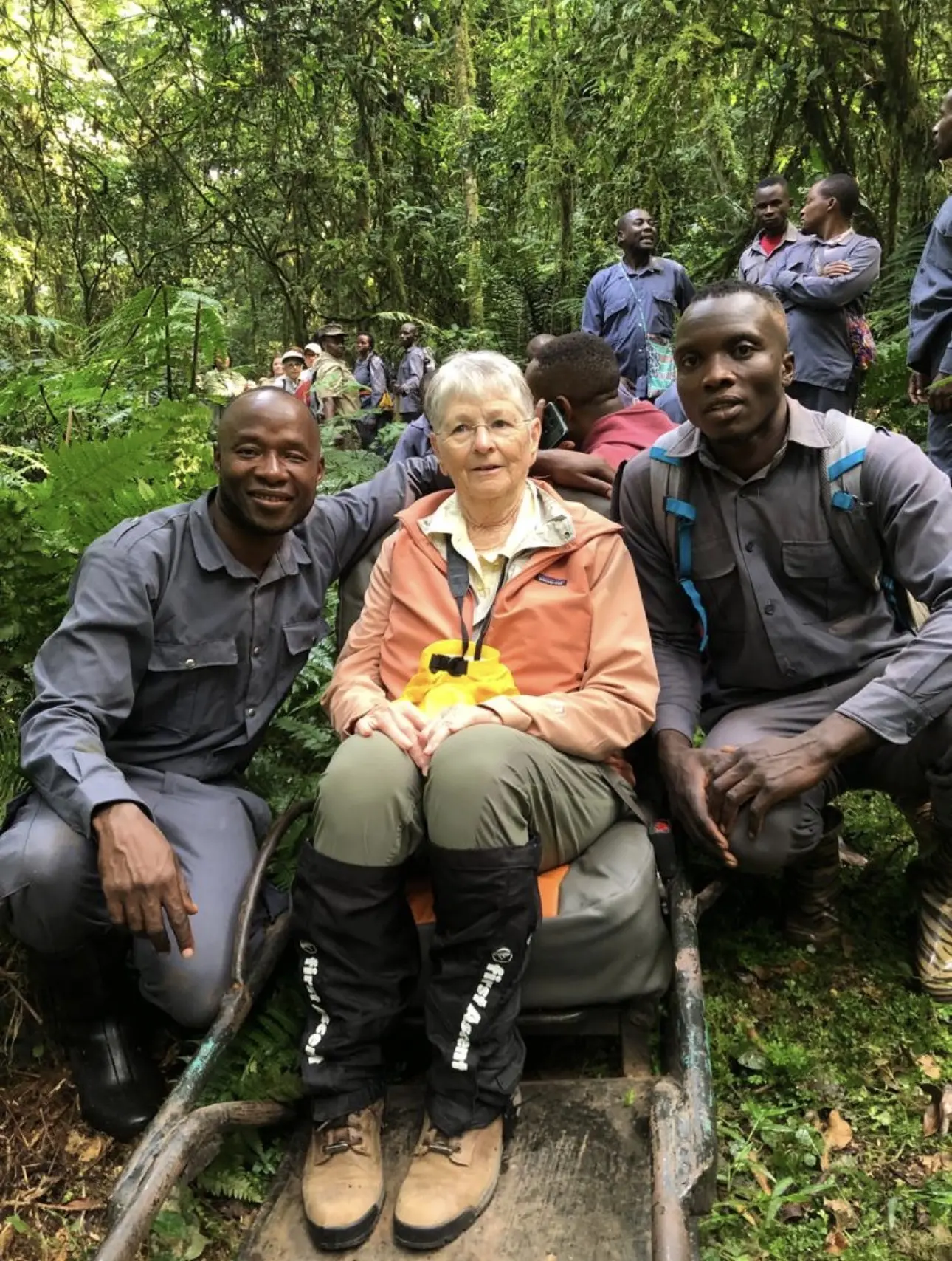 Porters assisting a traveller on a steep gorilla trekking trail in Bwindi