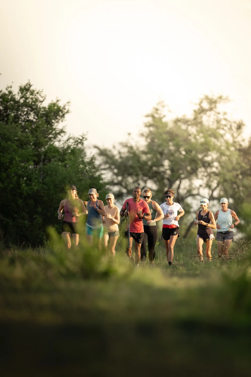 Young runners cross the green reserve in morning light