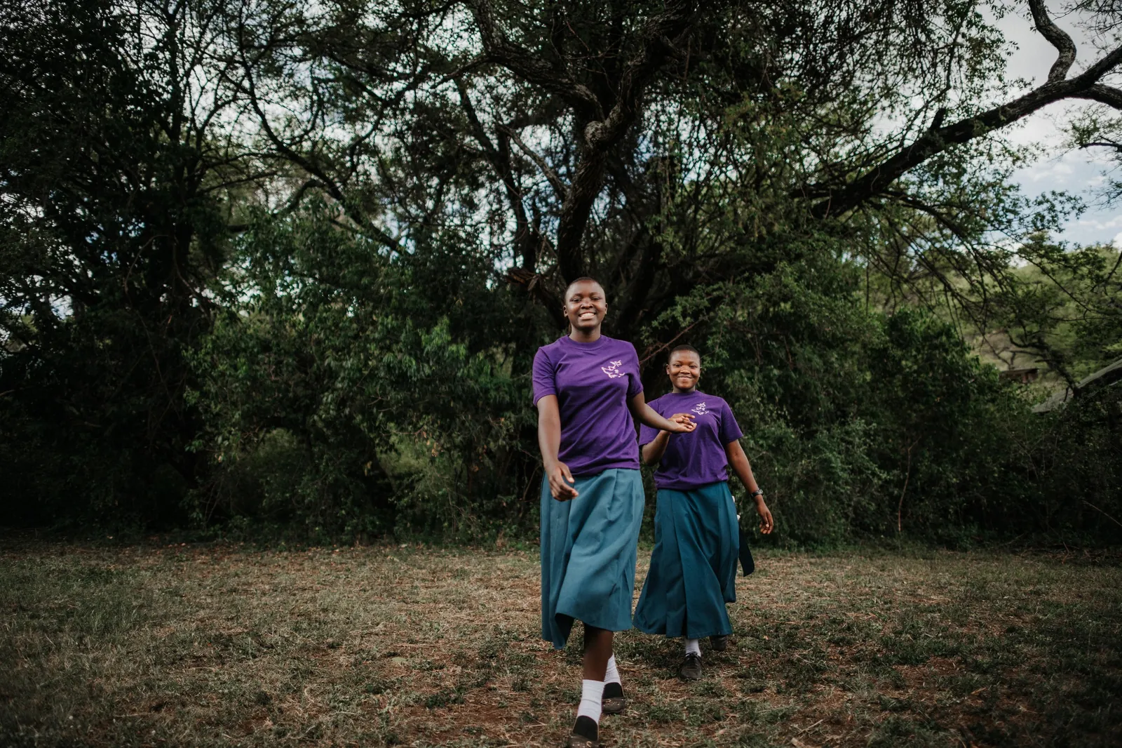 Two young participants walk the reserve path in team shirts