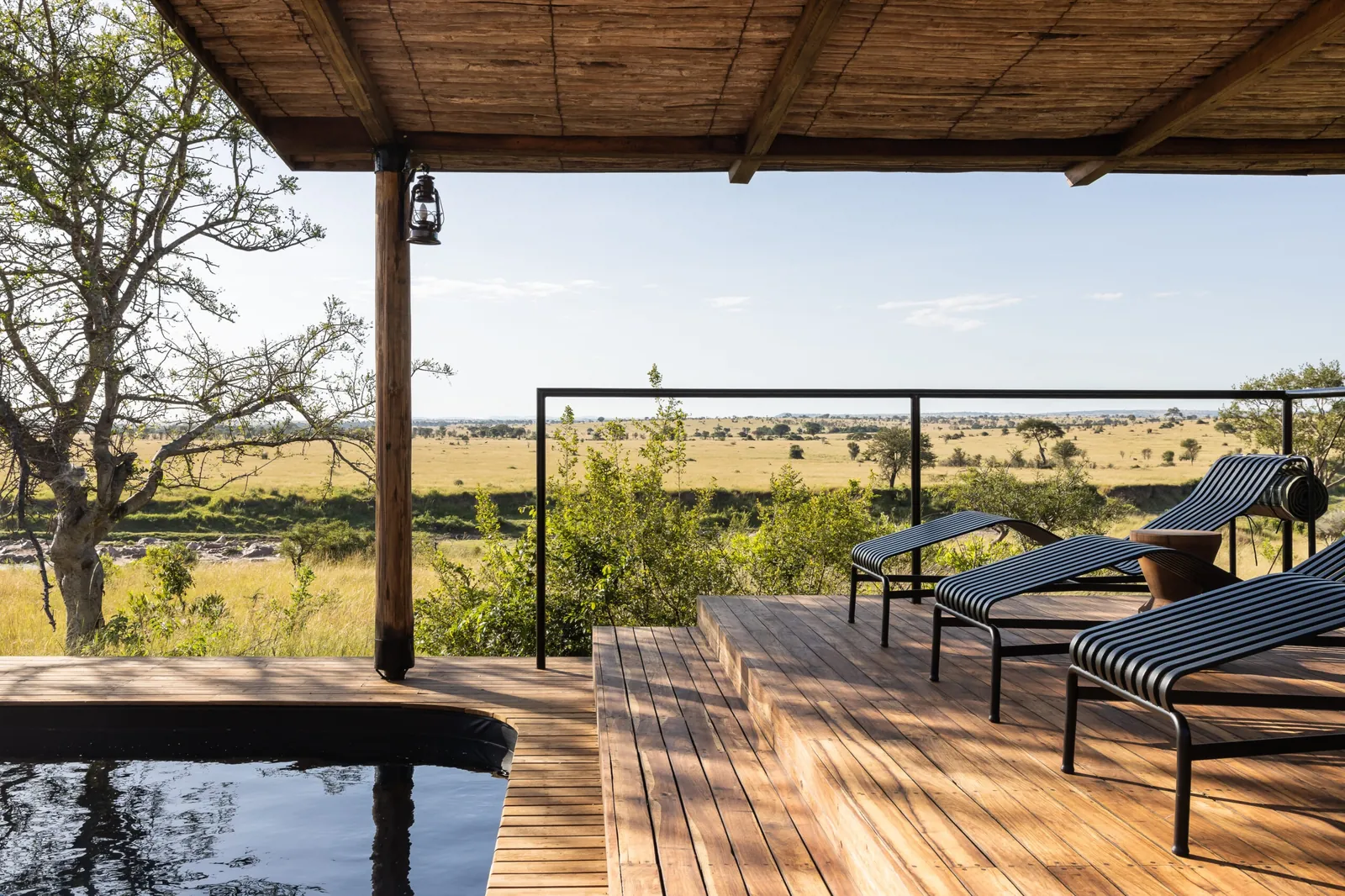 A camp deck and pool look out over the western Serengeti