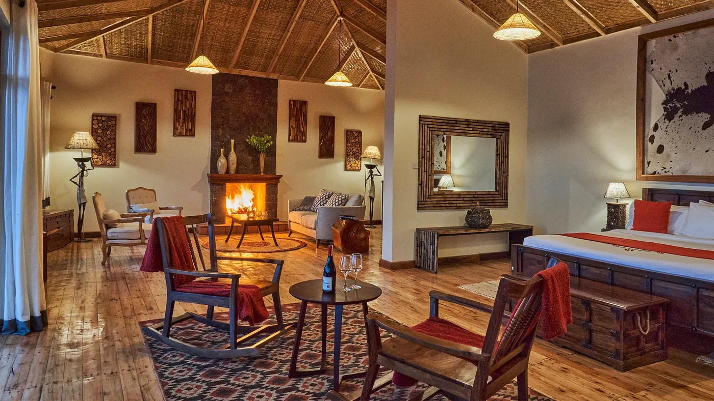 A suite interior at Nkuringo Bwindi Gorilla Lodge, looking through to the forest beyond the terrace