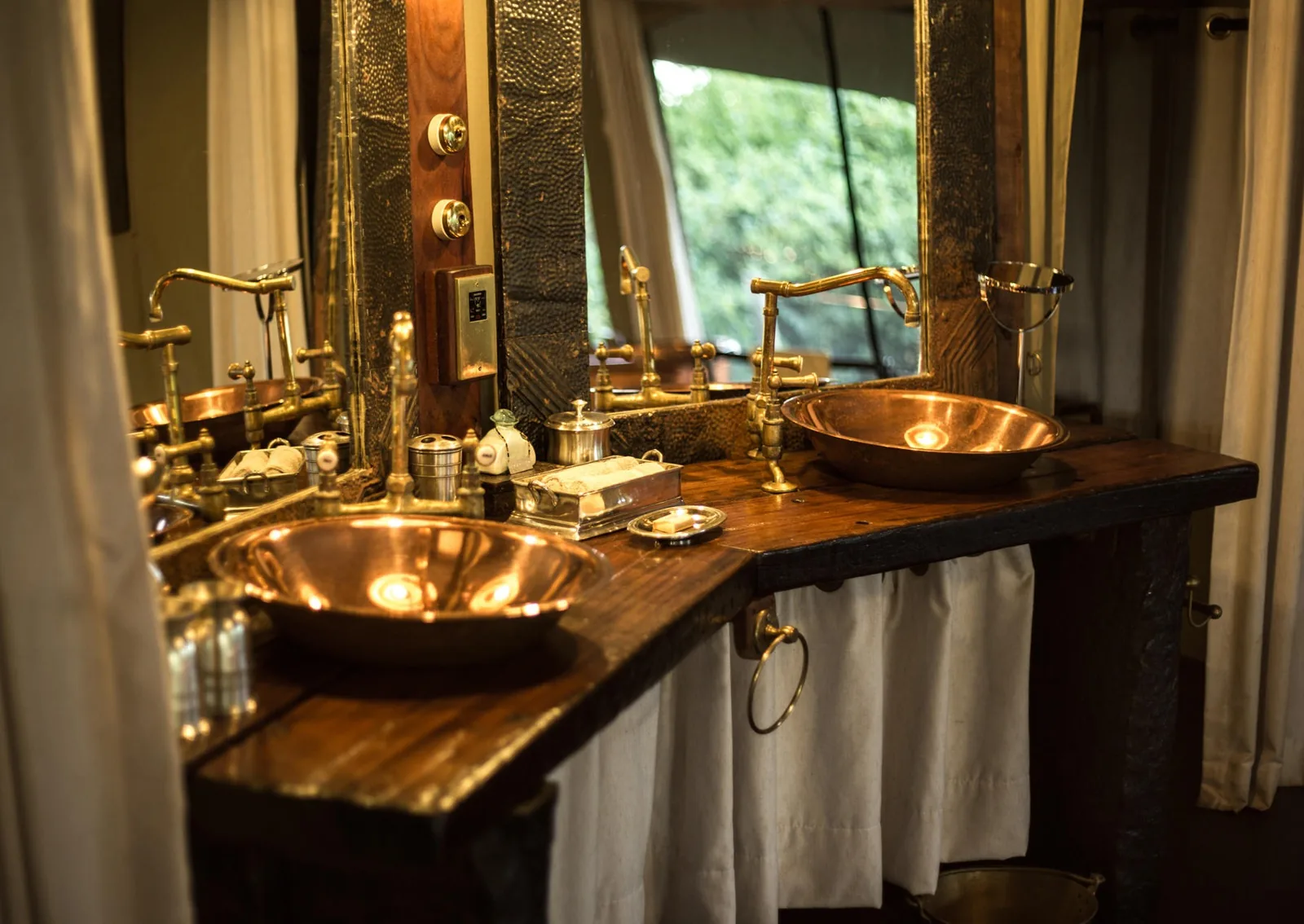 Hammered copper basins catch the light in a tented suite
