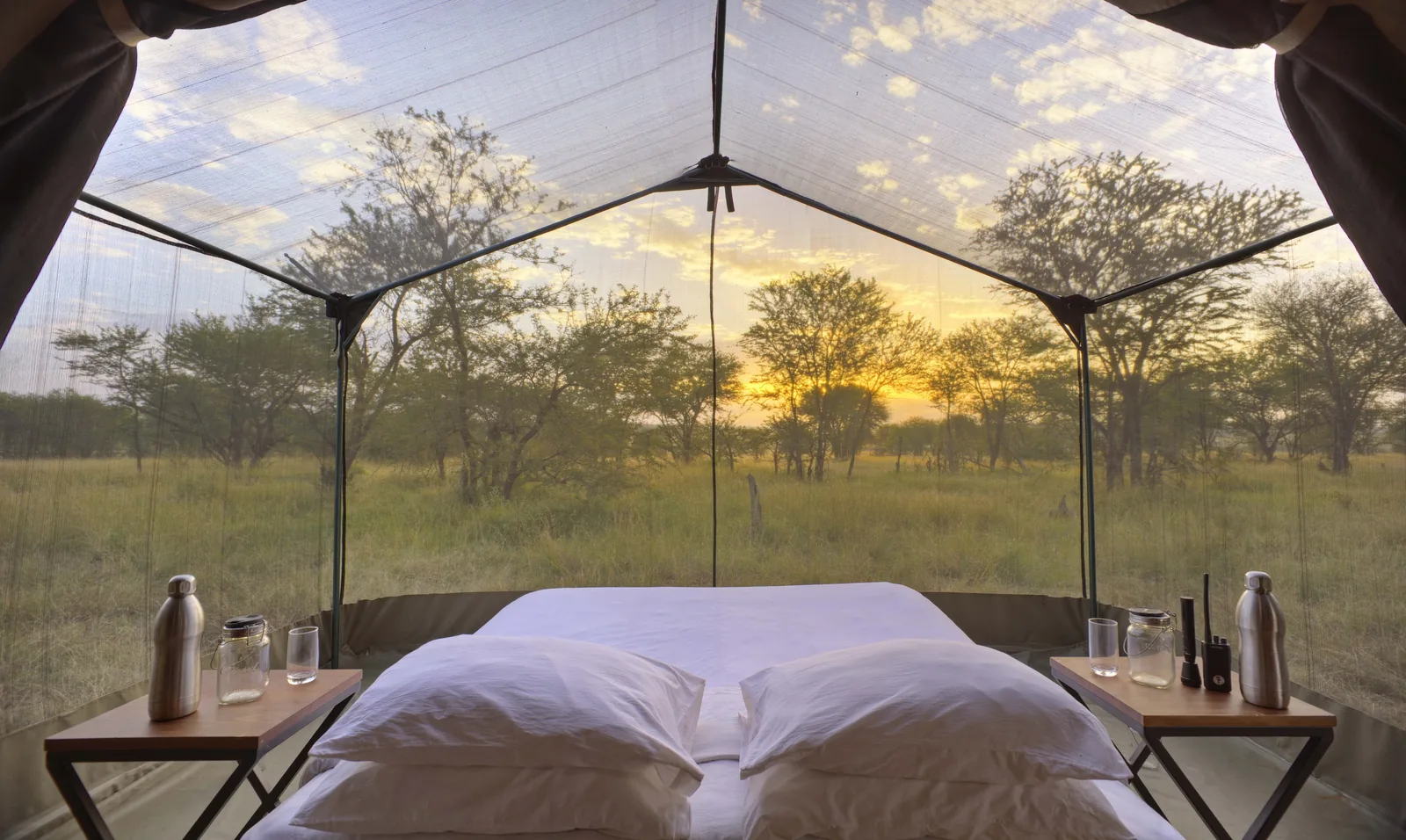 A star-gazing tent's bed looks straight onto the evening plain