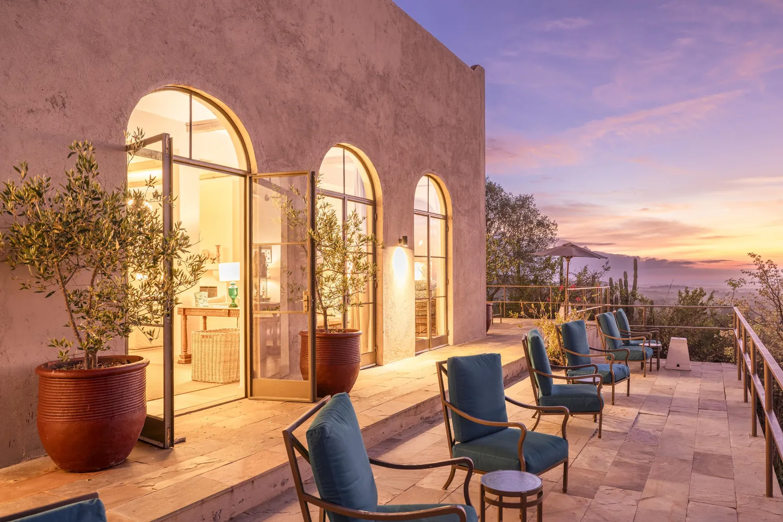Arched doorways open onto a terrace above the Laikipia plateau at dusk