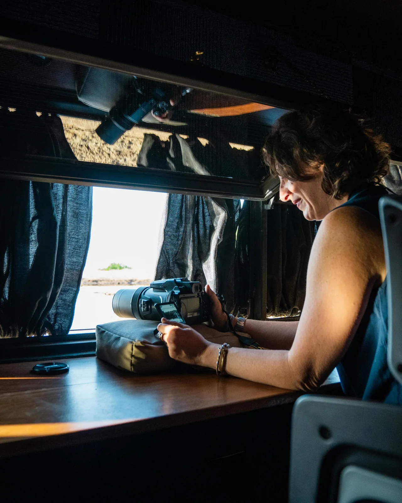 A photographer works a long lens through a hide's window at eye level