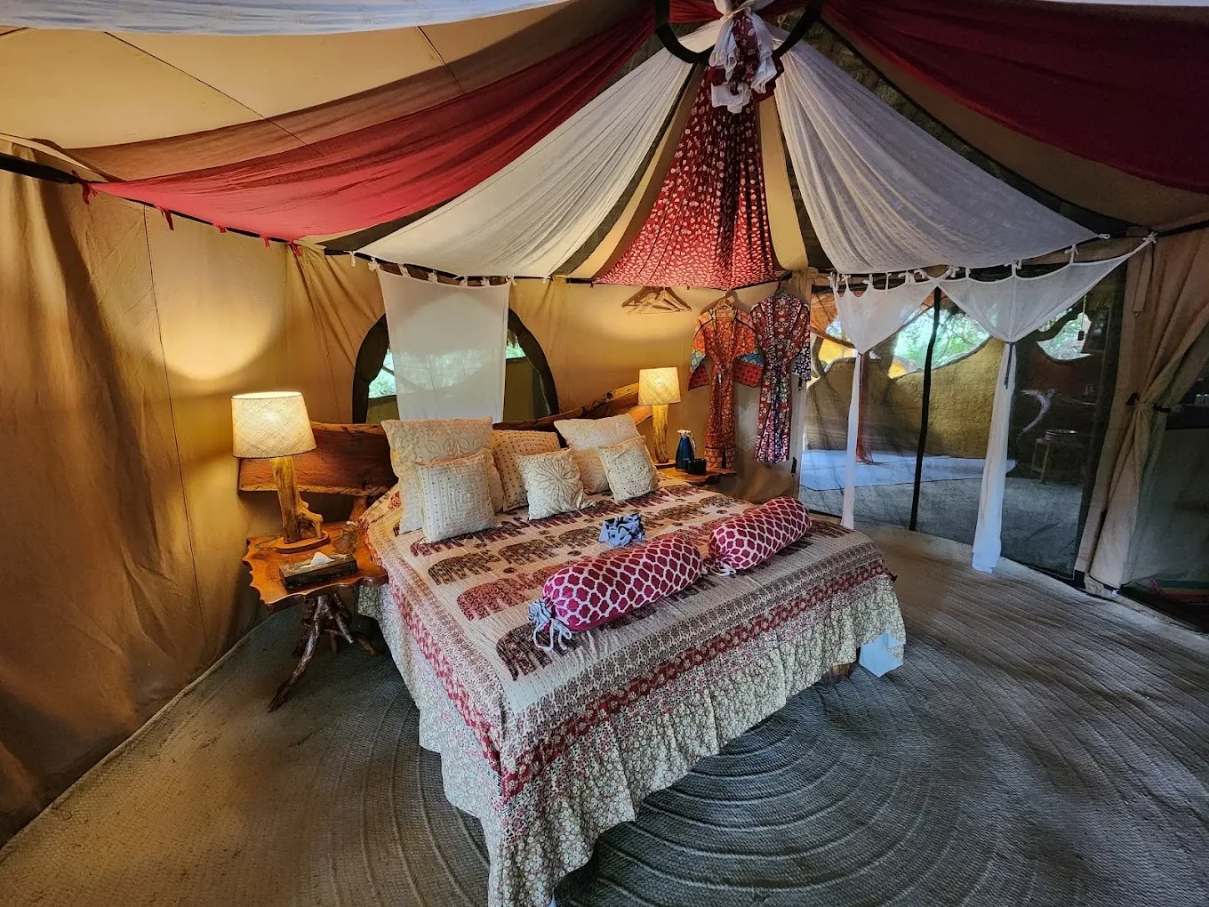 A tent hung in Samburu colour: rich fabrics over a wide bed