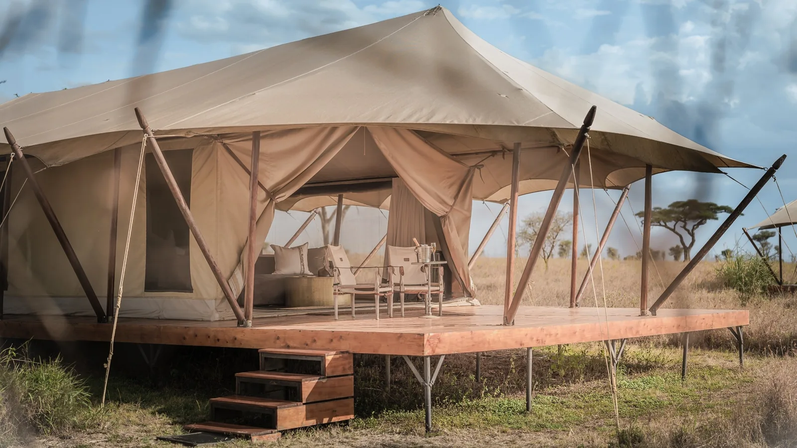 A seasonal tent stands ready on its wooden deck in the evening light