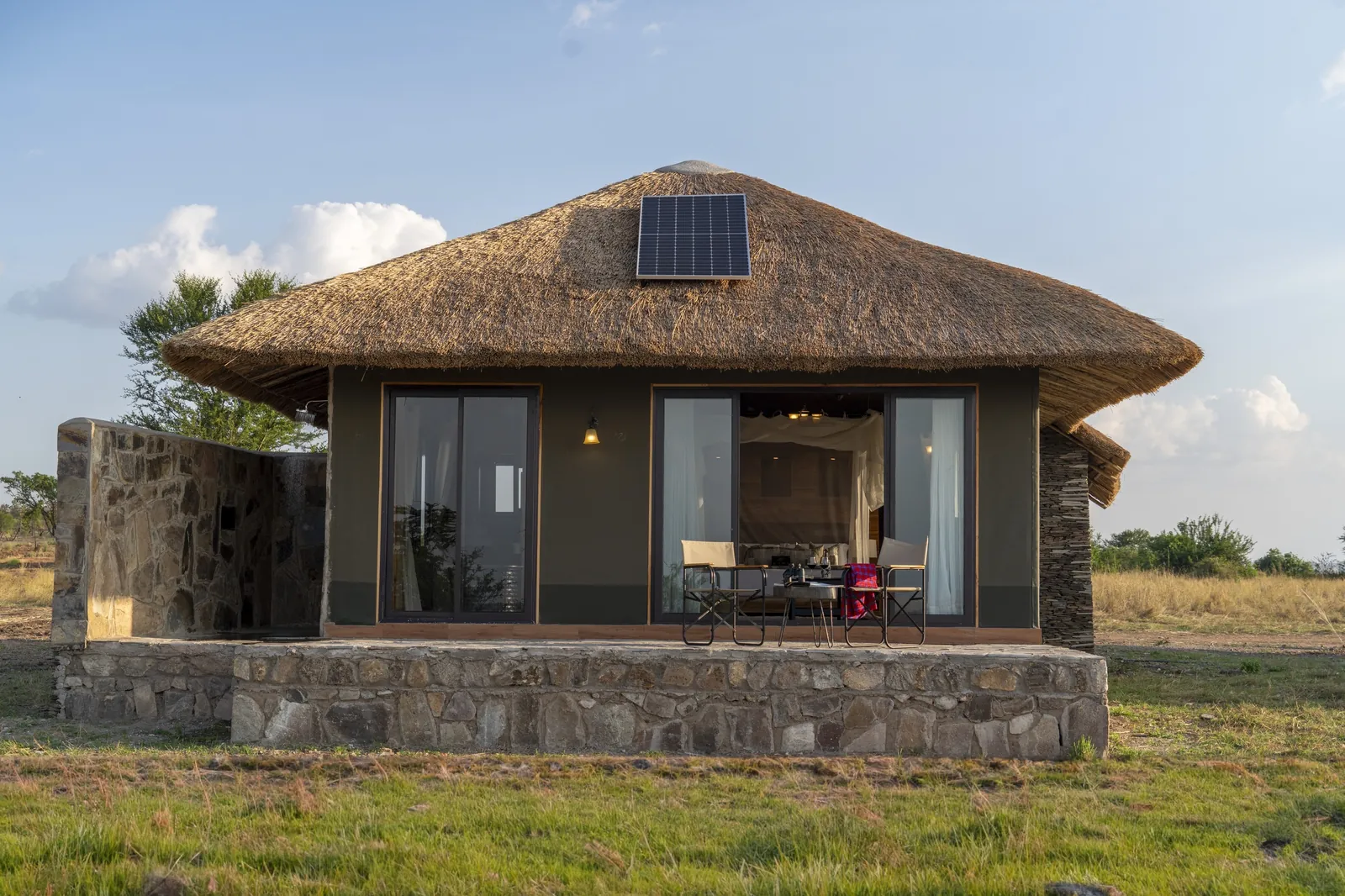 A stone and thatch suite stands over the river country