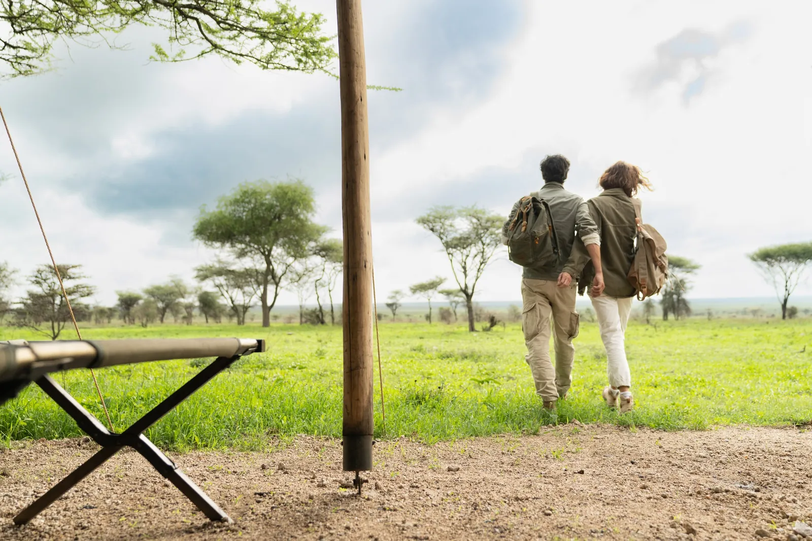 A couple walks out onto the plain from camp with their guide