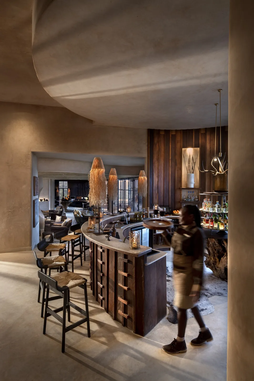 A camp bar glows in stone and lamplight