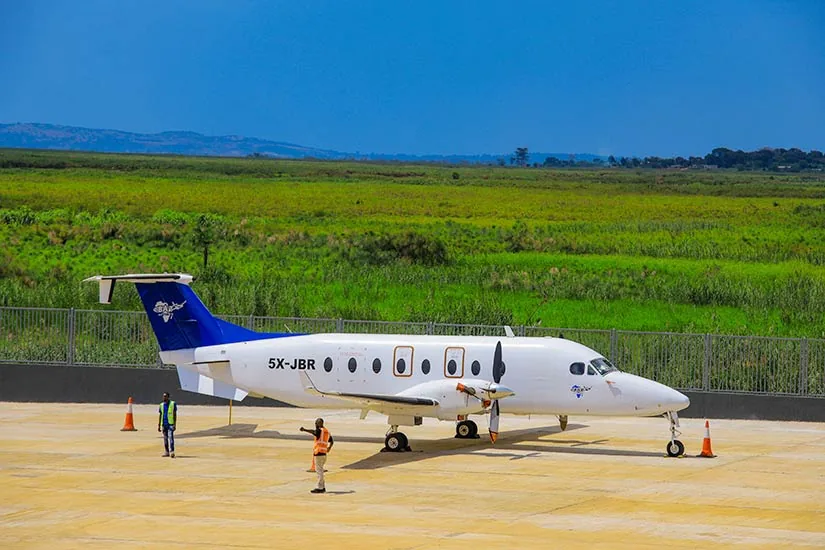 A charter turboprop waits on a green airstrip