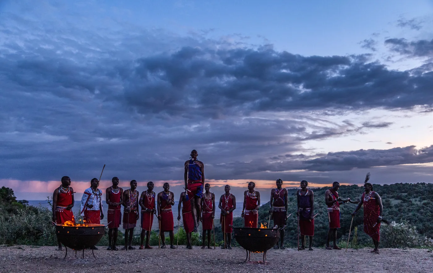 Maasai warriors gather at a sundowner boma as the sky turns