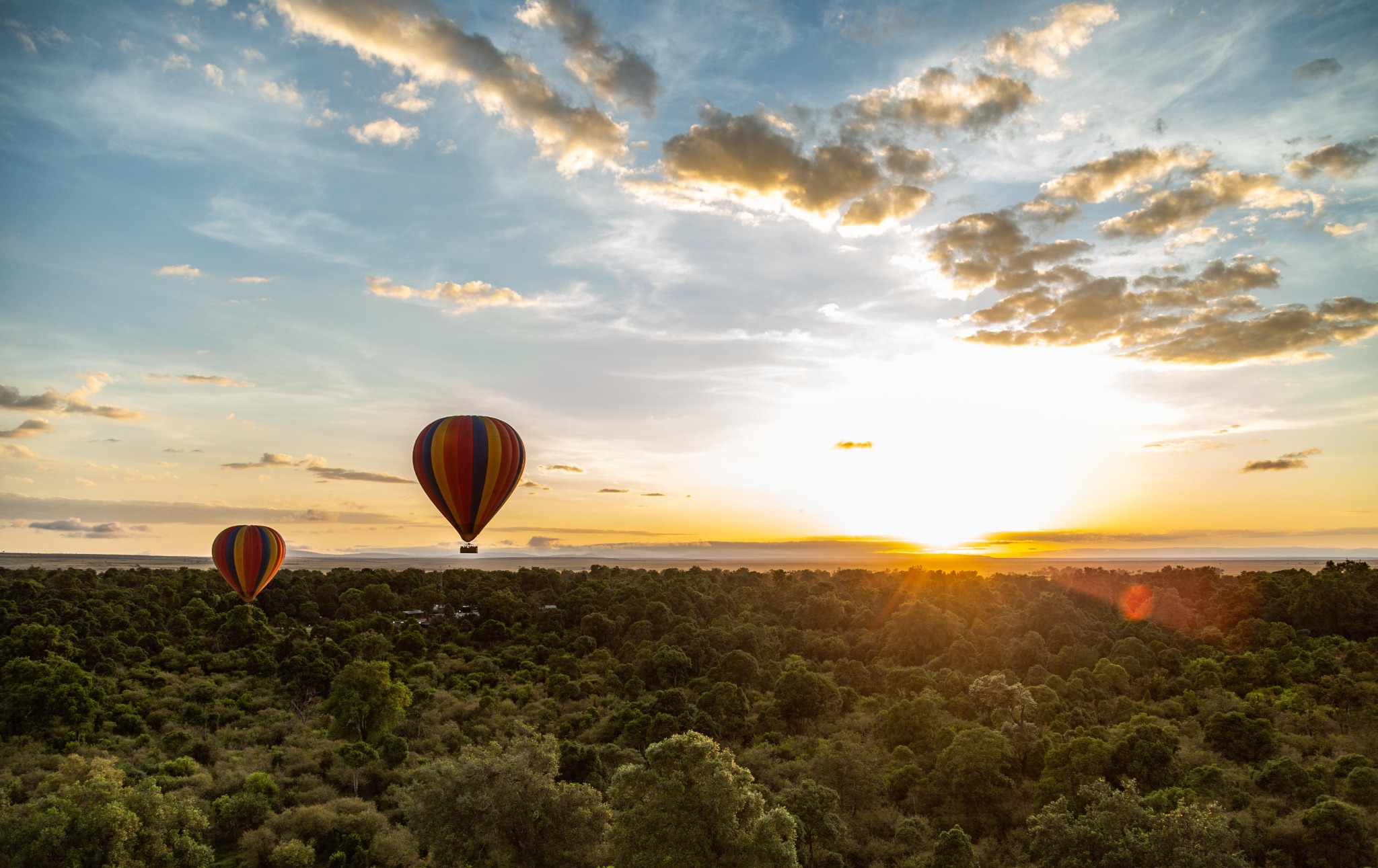 A hot-air balloon floating above Kenya's Maasai Mara at sunrise