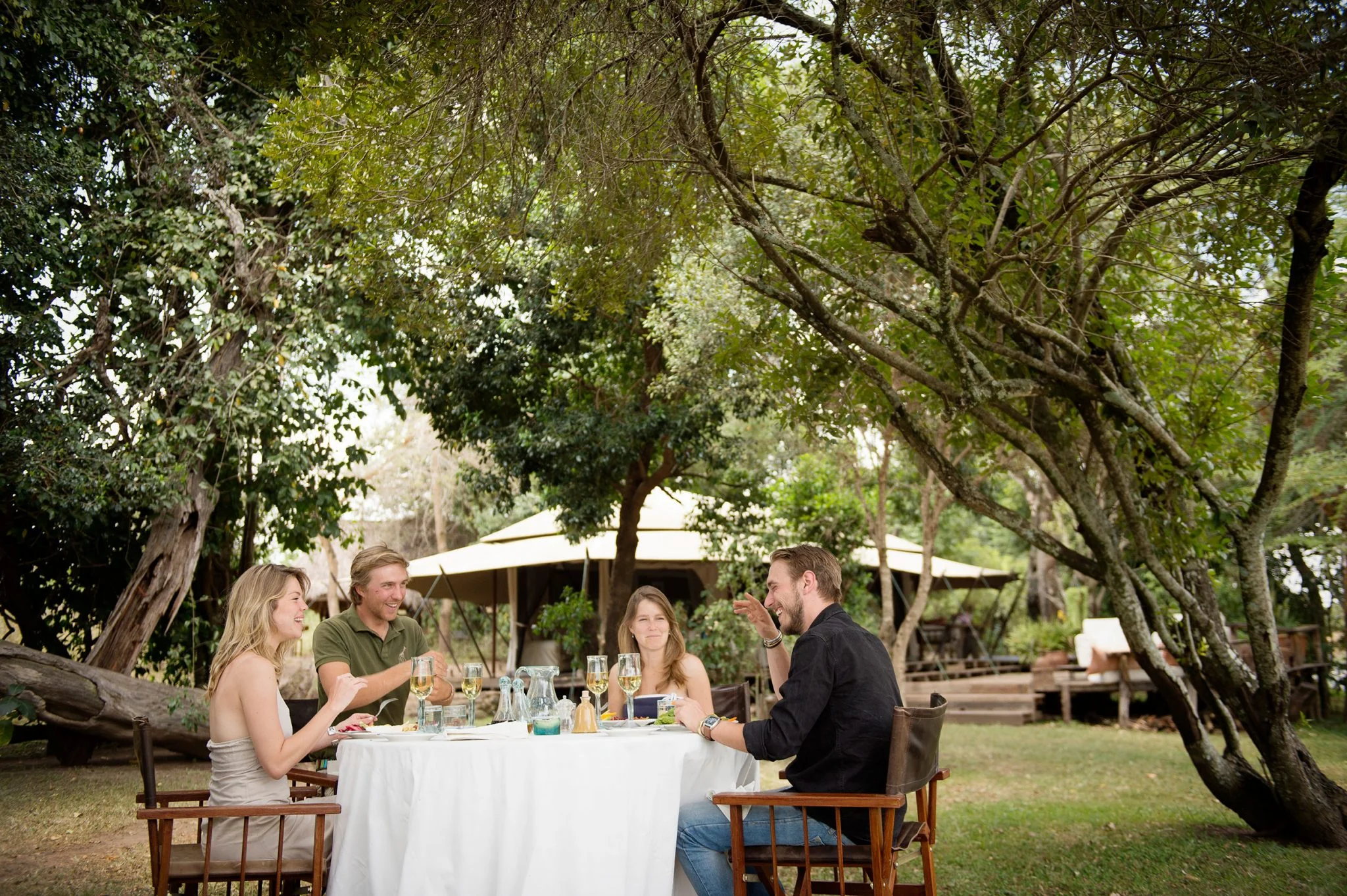 Guests at a table under the trees