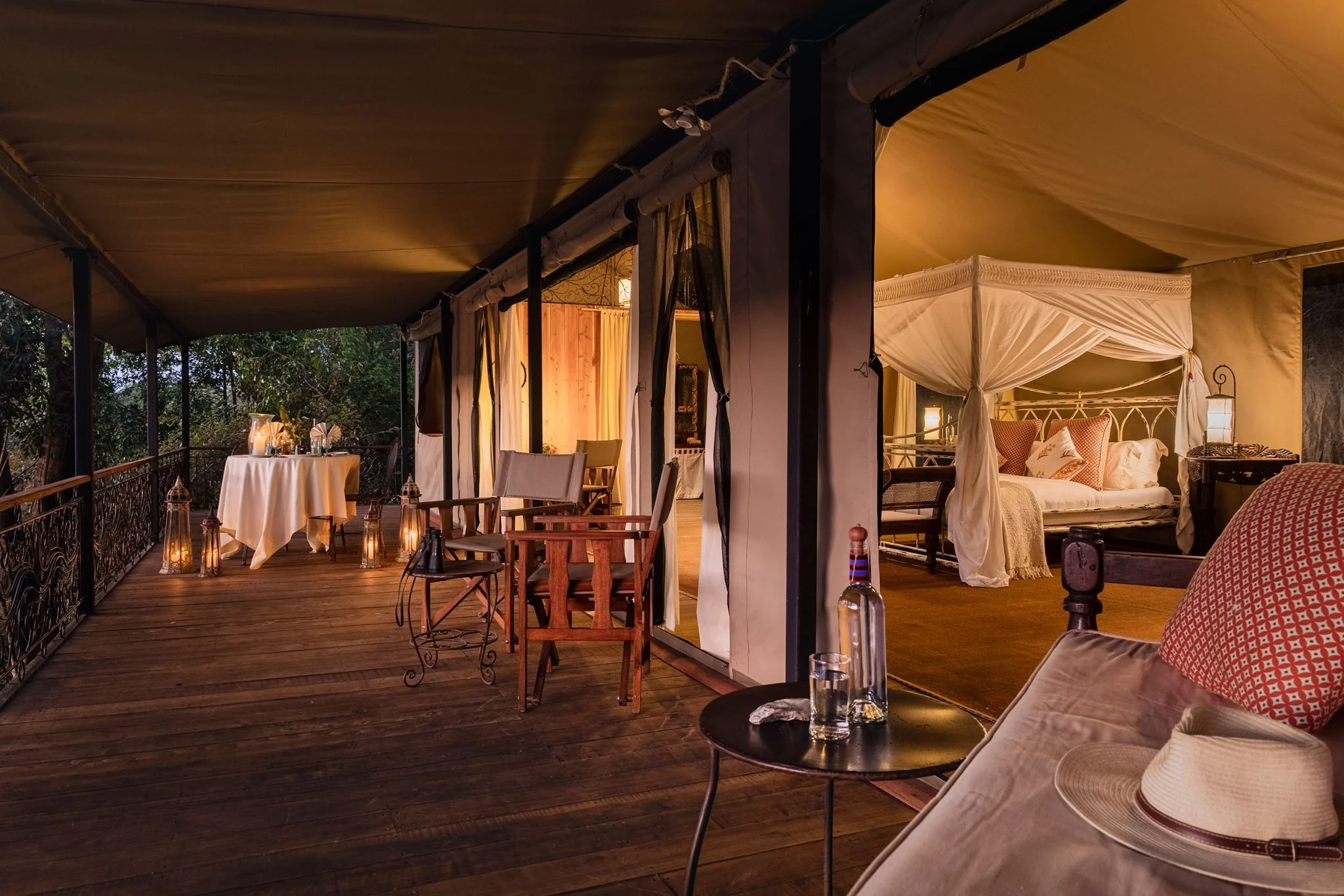 A tent interior with a dining table and the bed beyond