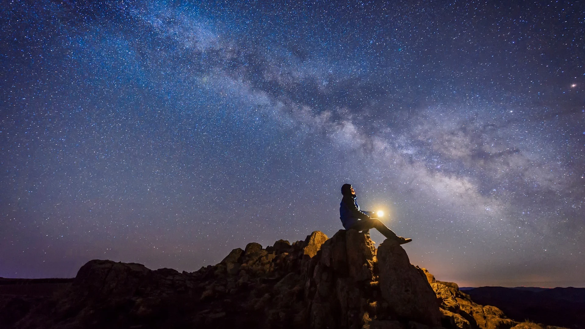A guest on a rock under the night sky