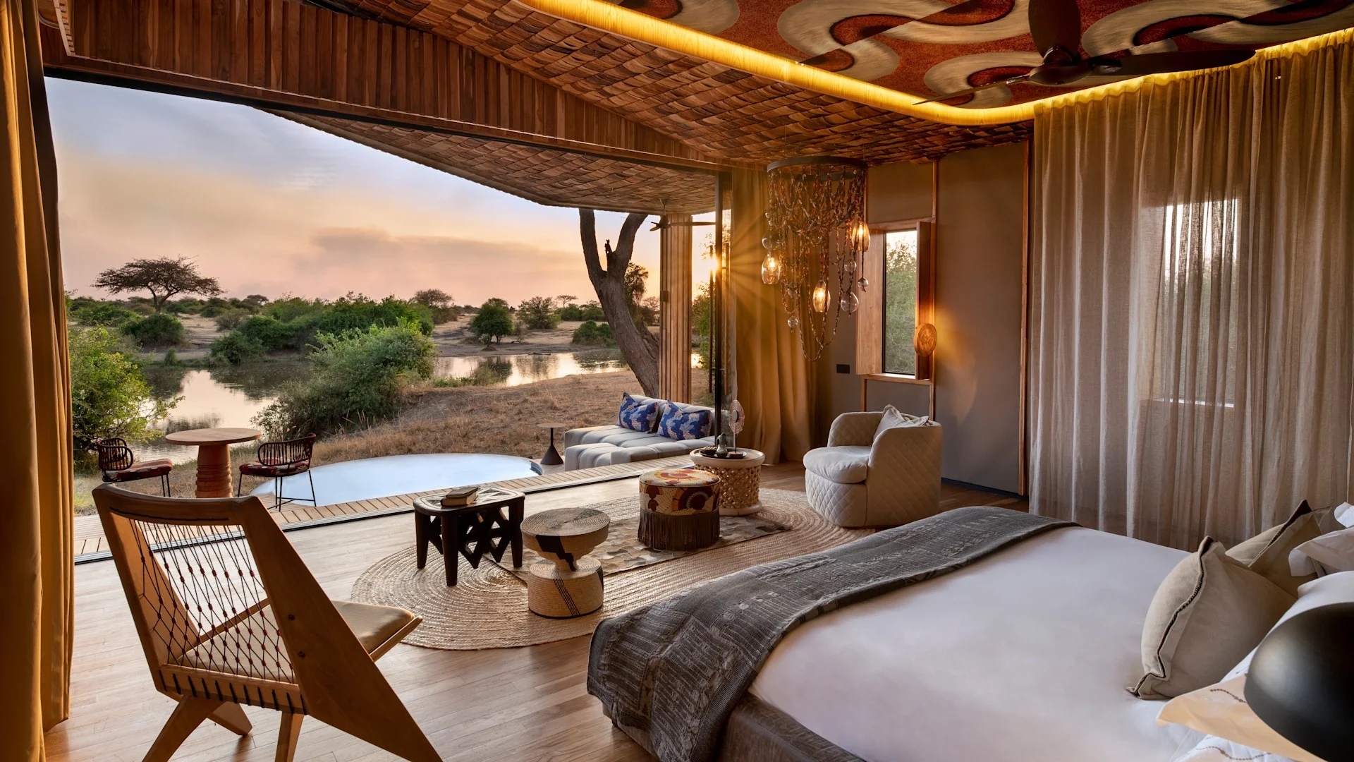 A suite interior with the bed, sitting area and the river beyond the open front