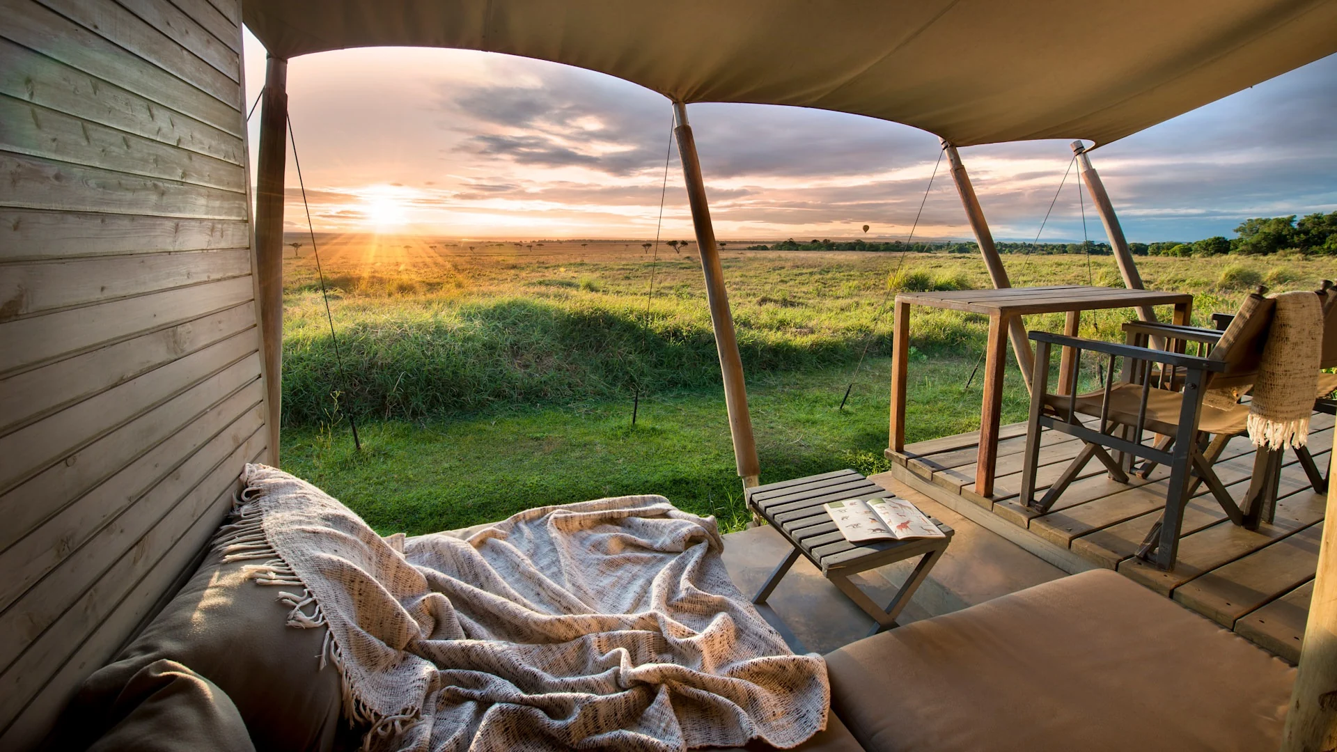 A tent deck at sunrise, looking over the plains