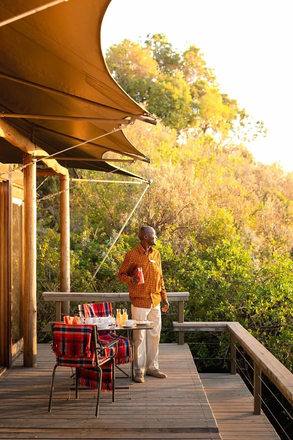 A member of staff on a tent deck above the trees