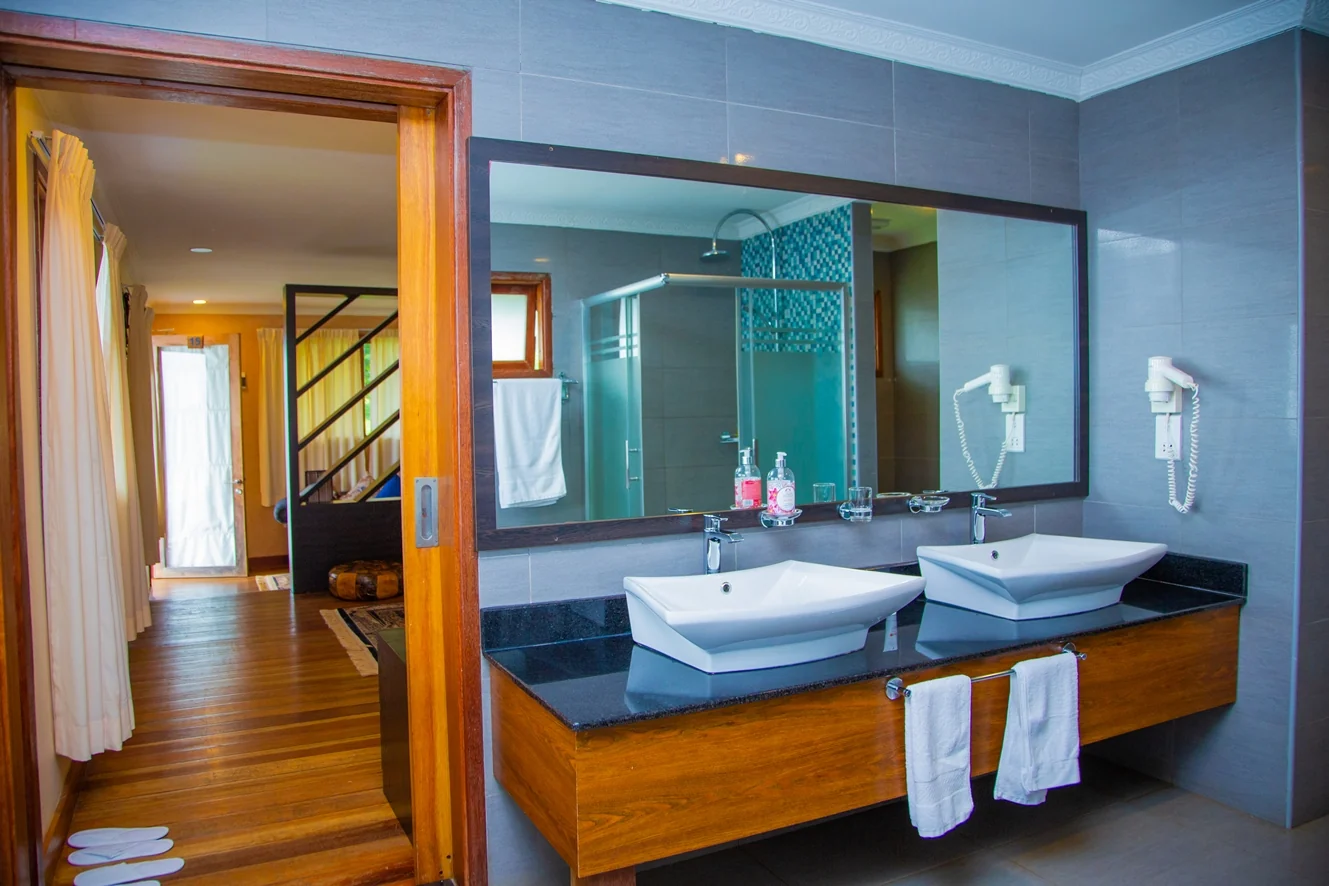A bathroom with twin basins and a large mirror