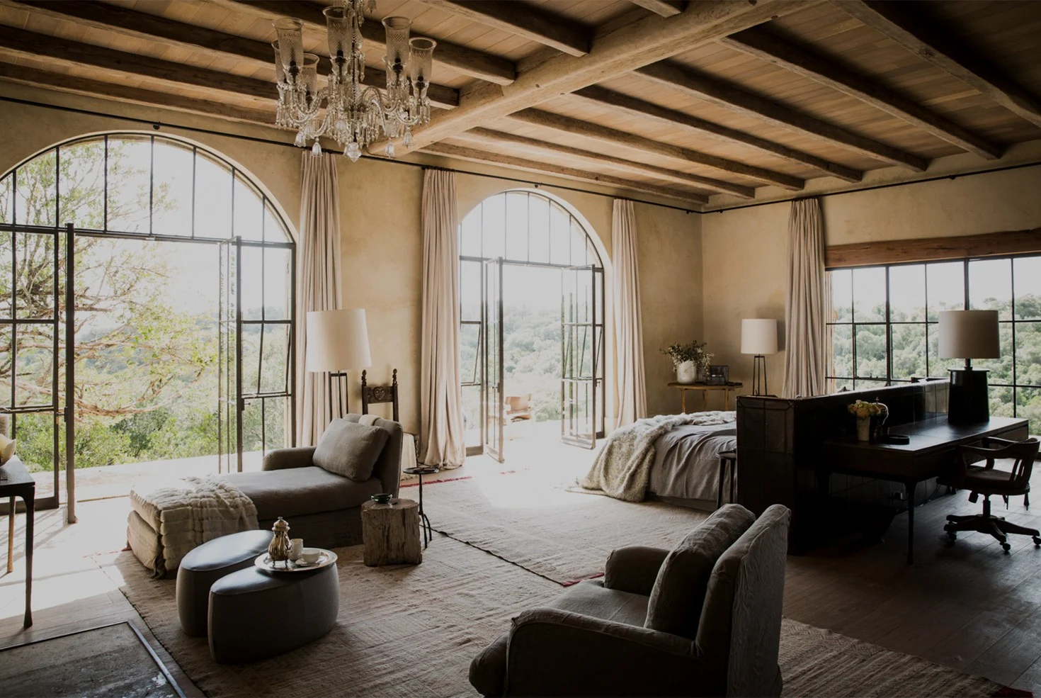 A bedroom with arched windows and a chandelier